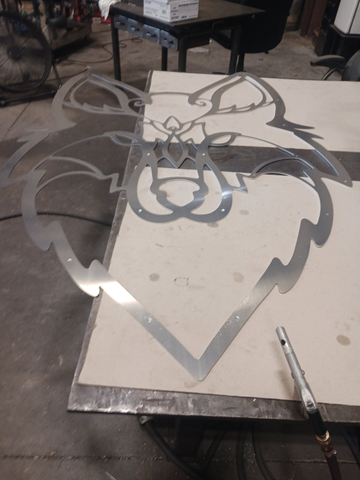 a freshly cut steel sheet depicting the face of a coyote